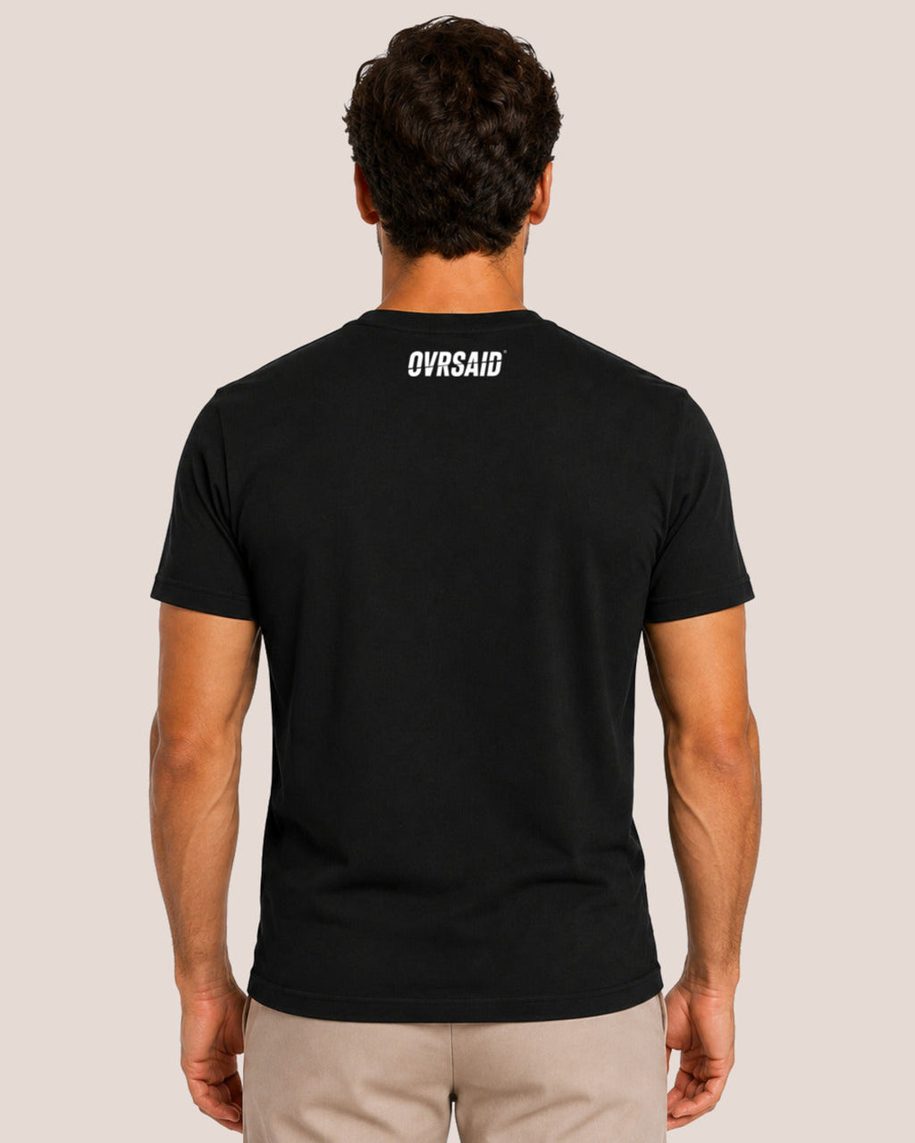 Color Black — Back view of male model wearing OVRSAID tee with white back-neck wordmark