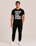 OVRSAID EVERYTHING I LOVE IS ILLEGAL EXPENSIVE OR BLONDE black statement tee worn by male model, front print
