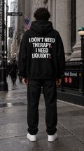 Color Black — OVRSAID I DON'T NEED THERAPY. I NEED LIQUIDITY. oversized hoodie on male model, back view showing the white back print