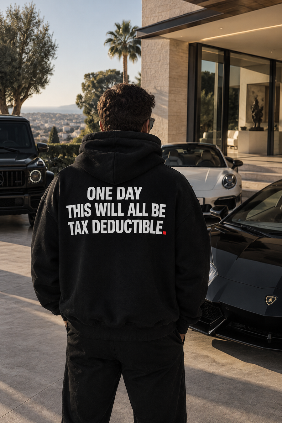 Color Black — OVRSAID ONE DAY THIS WILL ALL BE TAX DEDUCTIBLE. oversized hoodie on male model, back view showing the white back print