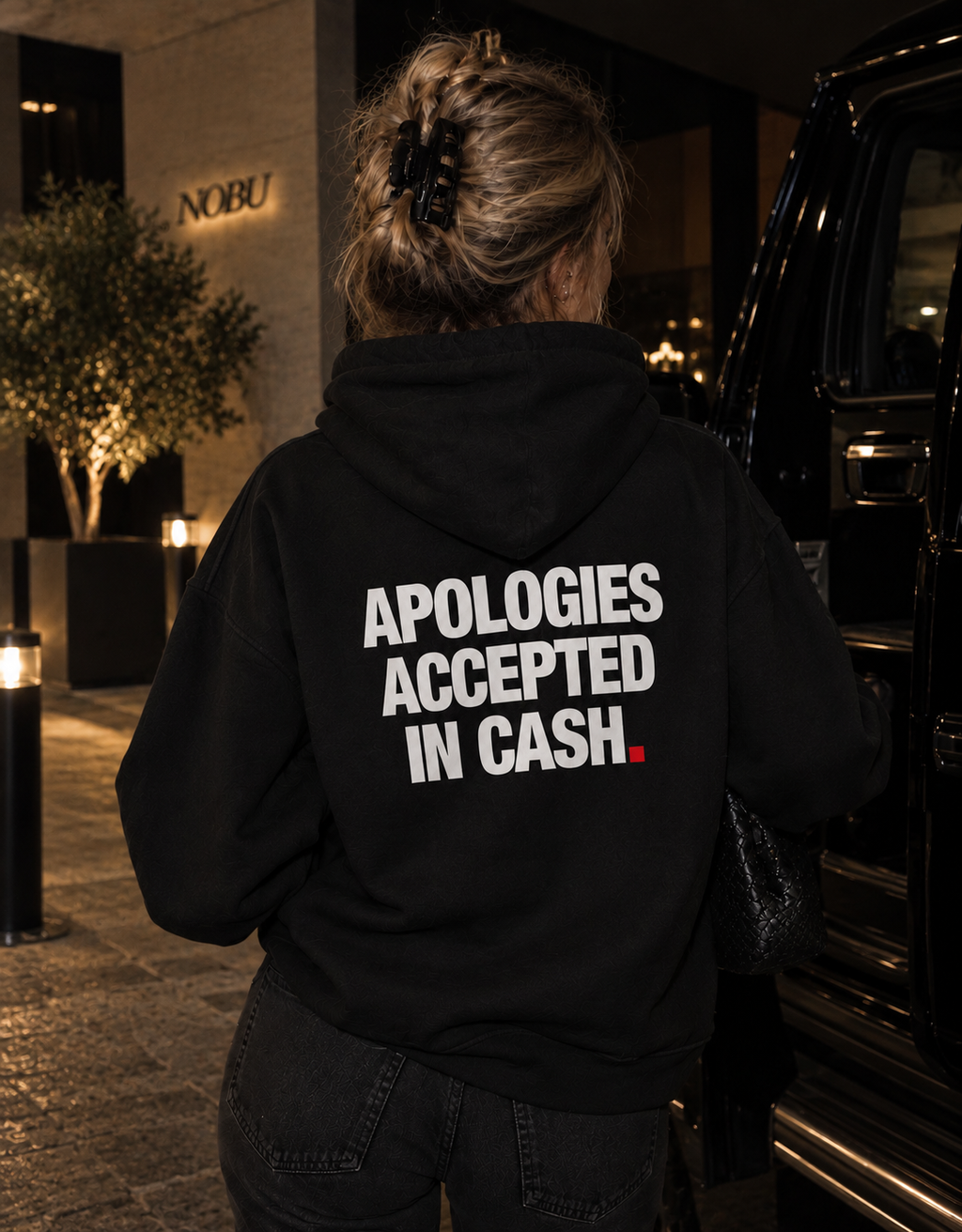 Color Black — OVRSAID APOLOGIES ACCEPTED IN CASH. oversized hoodie on female model, back view showing the white back print