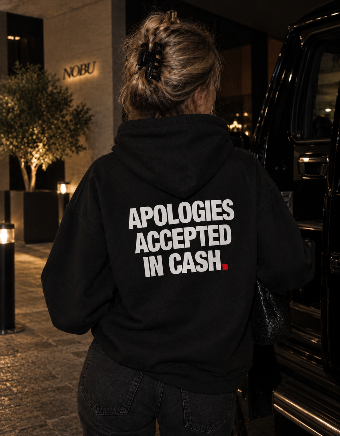 Color Black — OVRSAID APOLOGIES ACCEPTED IN CASH. oversized hoodie on female model, back view showing the white back print