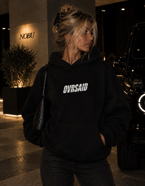 Color Black — OVRSAID APOLOGIES ACCEPTED IN CASH. oversized hoodie on female model, front view with small OVRSAID chest mark